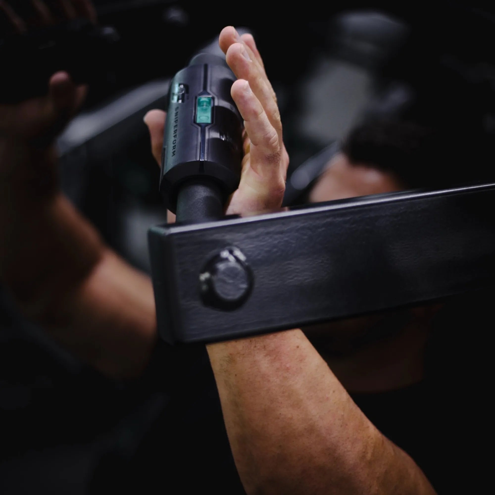 Athlete gripping barbell with Sniperform LevelUp Performance Grip showing teal level indicator in gym